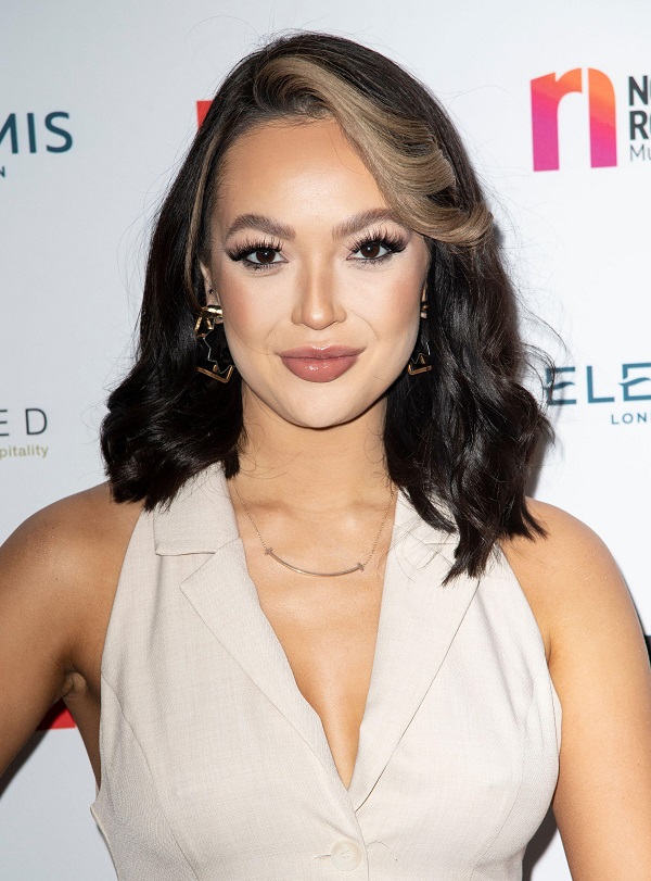 Sharon Gaffka, a young woman with dark hair wearing glamorous smoky eye make up and a beige dress